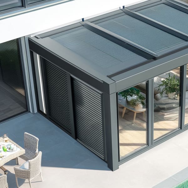 Wintergarten am Pool mit dunkelgrauen Rollladen.