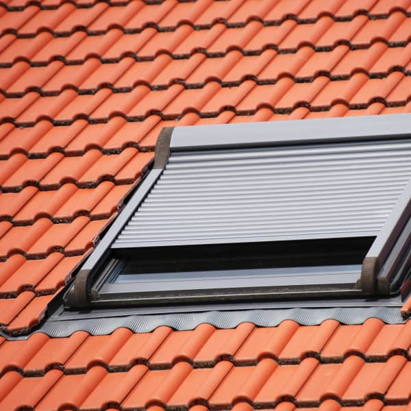 Dachfenster mit halb geschlossenem Rollladen.