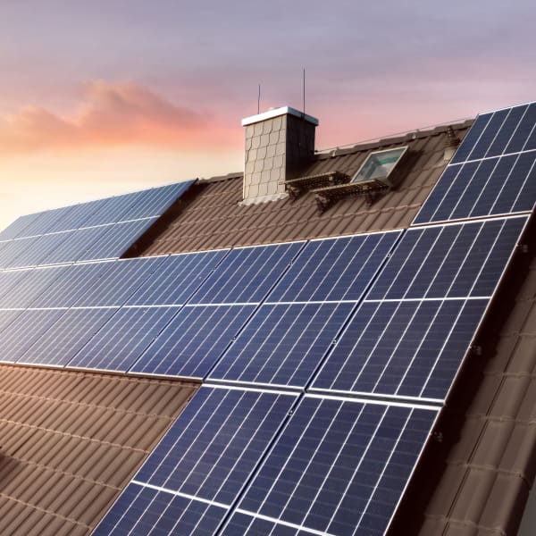 Solaranlage auf einem braunen Hausdach bei Sonnenuntergang