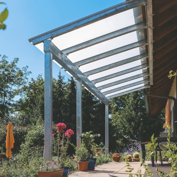 Terrassenüberdachung aus Metall, die an ein Vordach angebaut ist.
