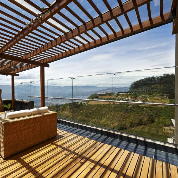 Holz-Terrassenüberdachung mit Glasdach und schönem Ausblick von Terrasse.