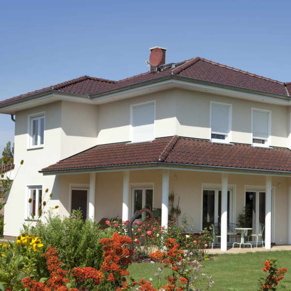 zweistöckiges Haus mit einer Terrasse mit Ziegeldach