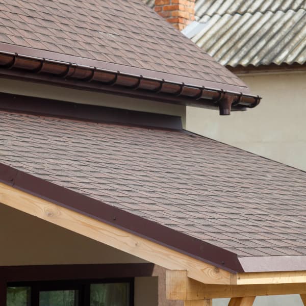 Terrassenüberdachung aus Holz mit Ziegeldach, angepasst an Optik des Hausdachs.