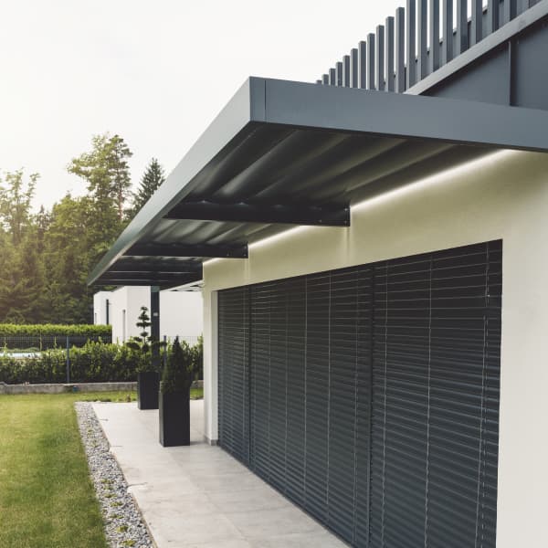 Vordach über einer Terrasse eines modernen Hauses.