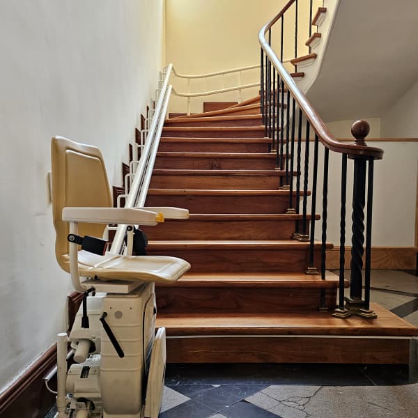 Sitzlift an einer Wendeltreppe eines Mehrfamilienhauses.