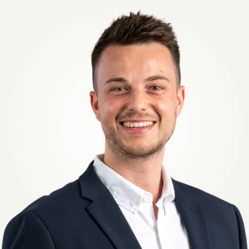 Porträt von Swen Dreßen, Experte für barrierefreies Wohnen bei Aroundhome, lächelnd in einem dunklen Sakko und hellem Hemd vor neutralem Hintergrund.