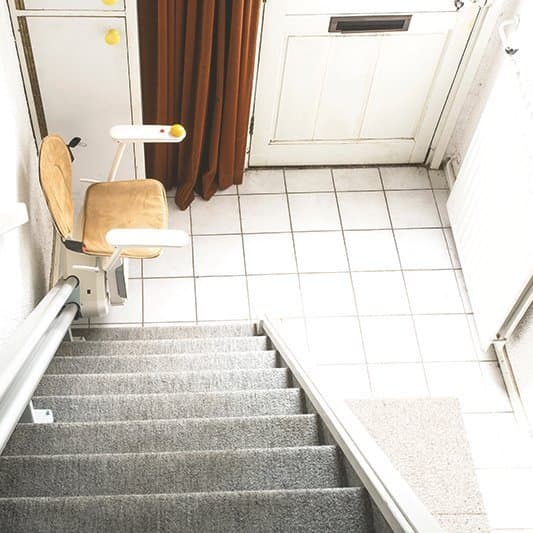 Ein Sitzlift an einer Treppe im Eingangsbereich.