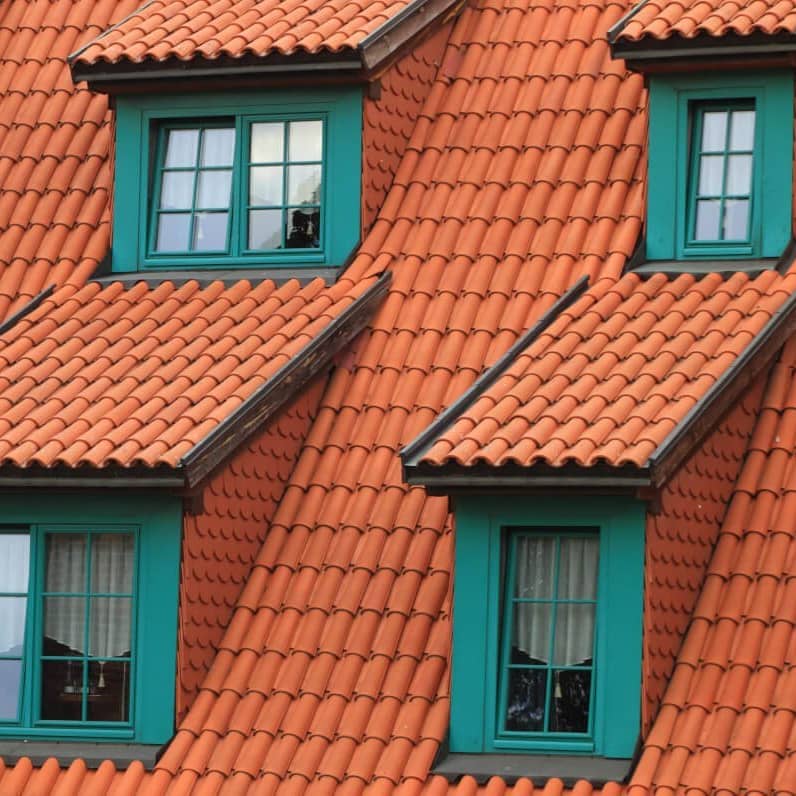 Haus mit roten Dachziegeln und grünen Sprossenfenstern