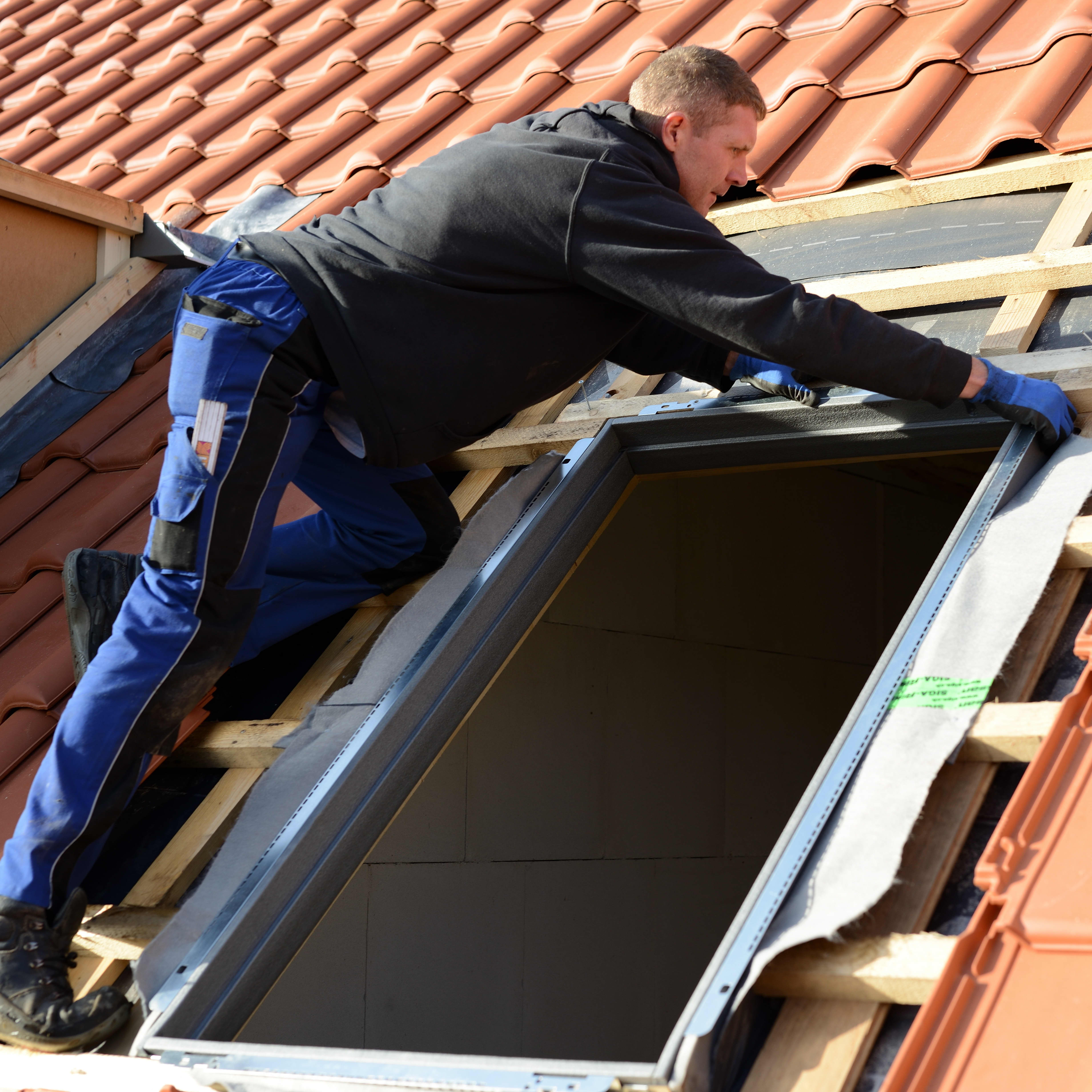 Handwerker baut Dachfenster ein