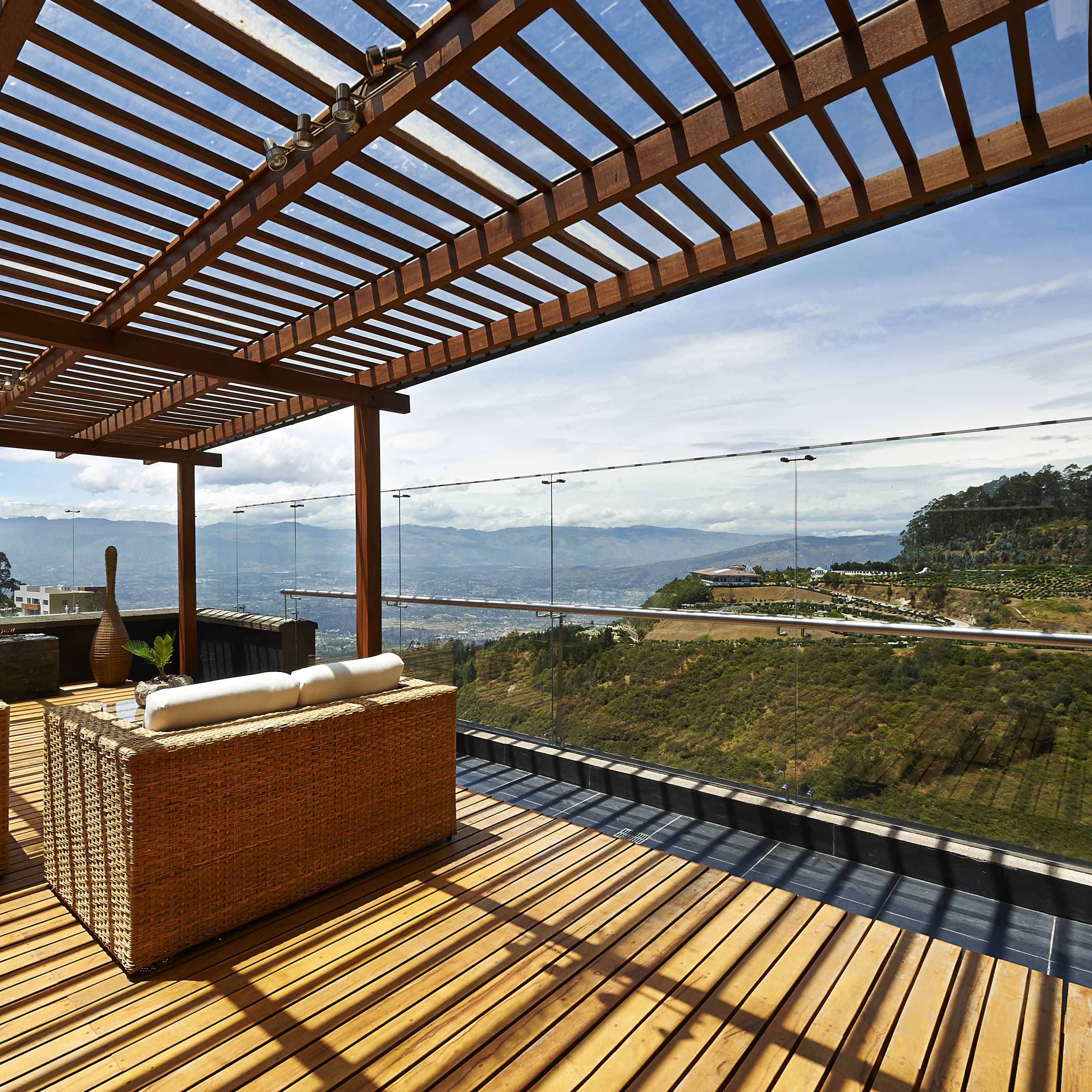 Holz-Terrassenüberdachung mit Glasdach und schönem Ausblick von Terrasse.