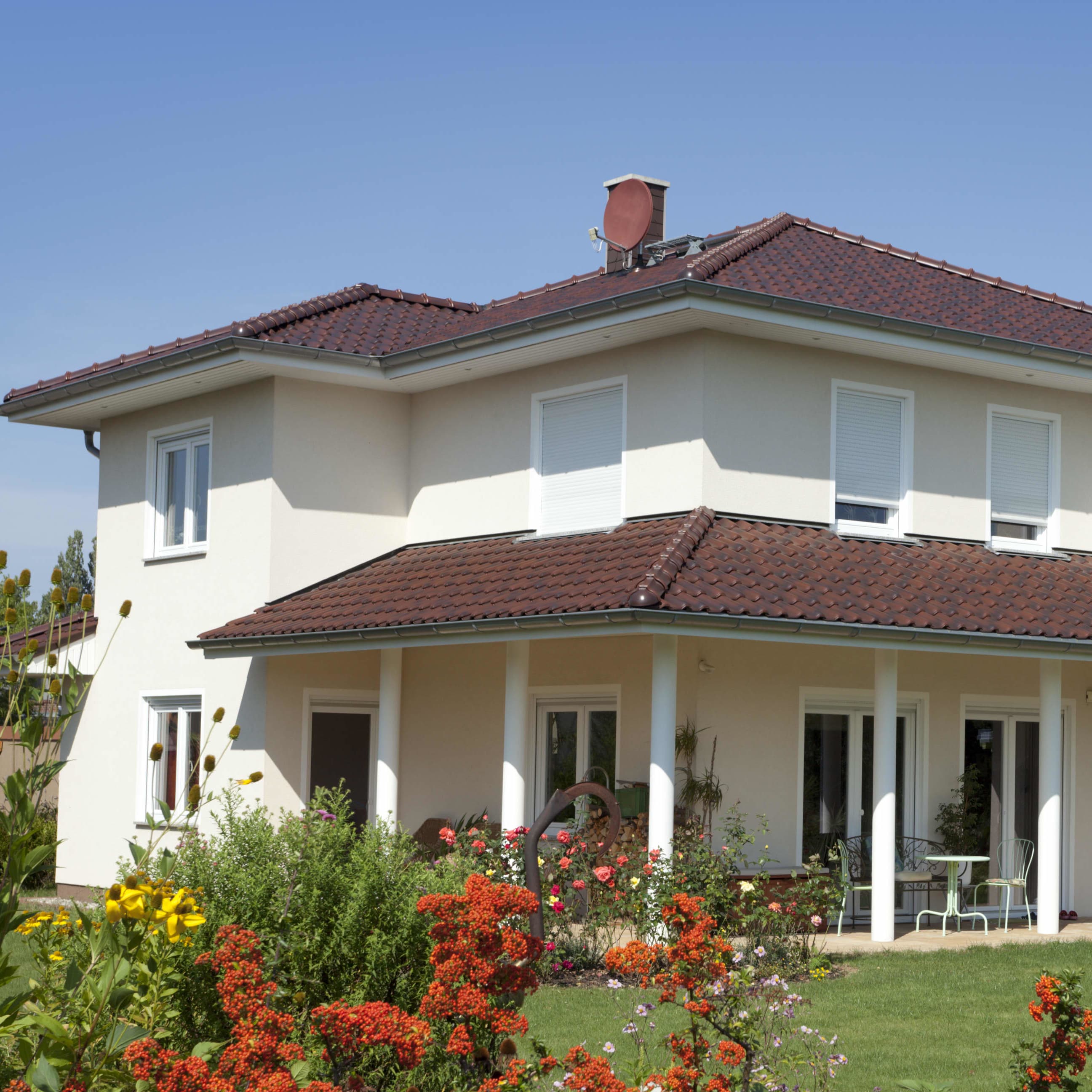 zweistöckiges Haus mit einer Terrasse mit Ziegeldach