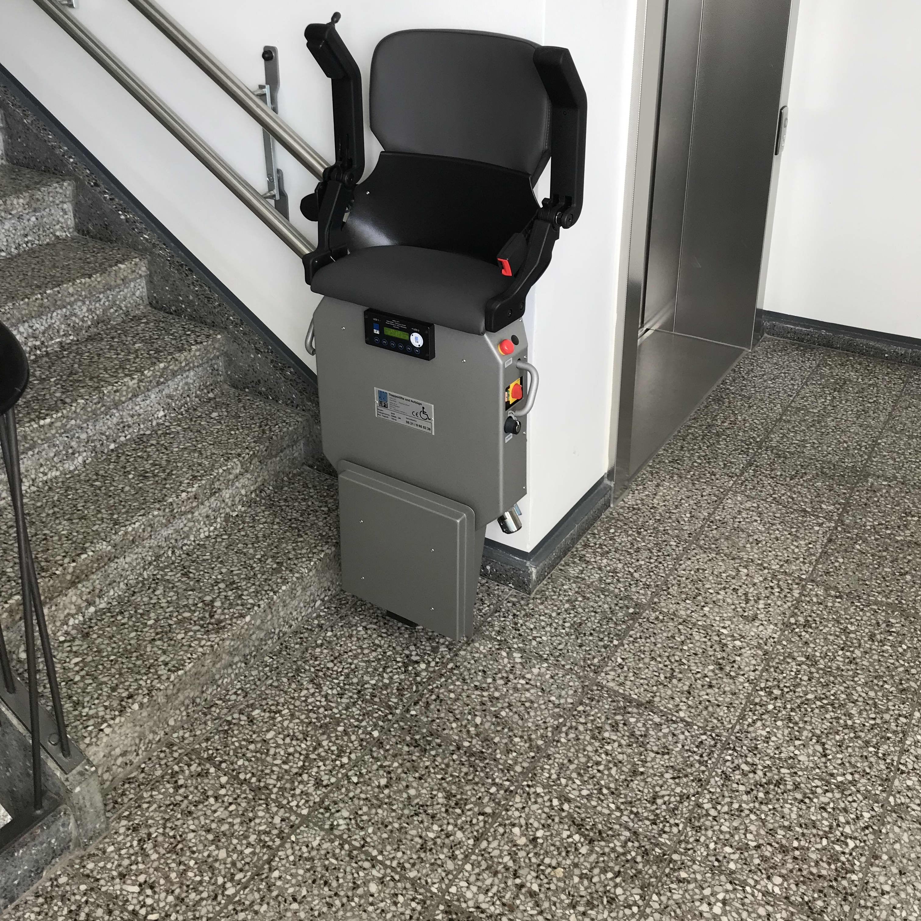 Treppenlift zum Stehen in einem Treppenhaus.