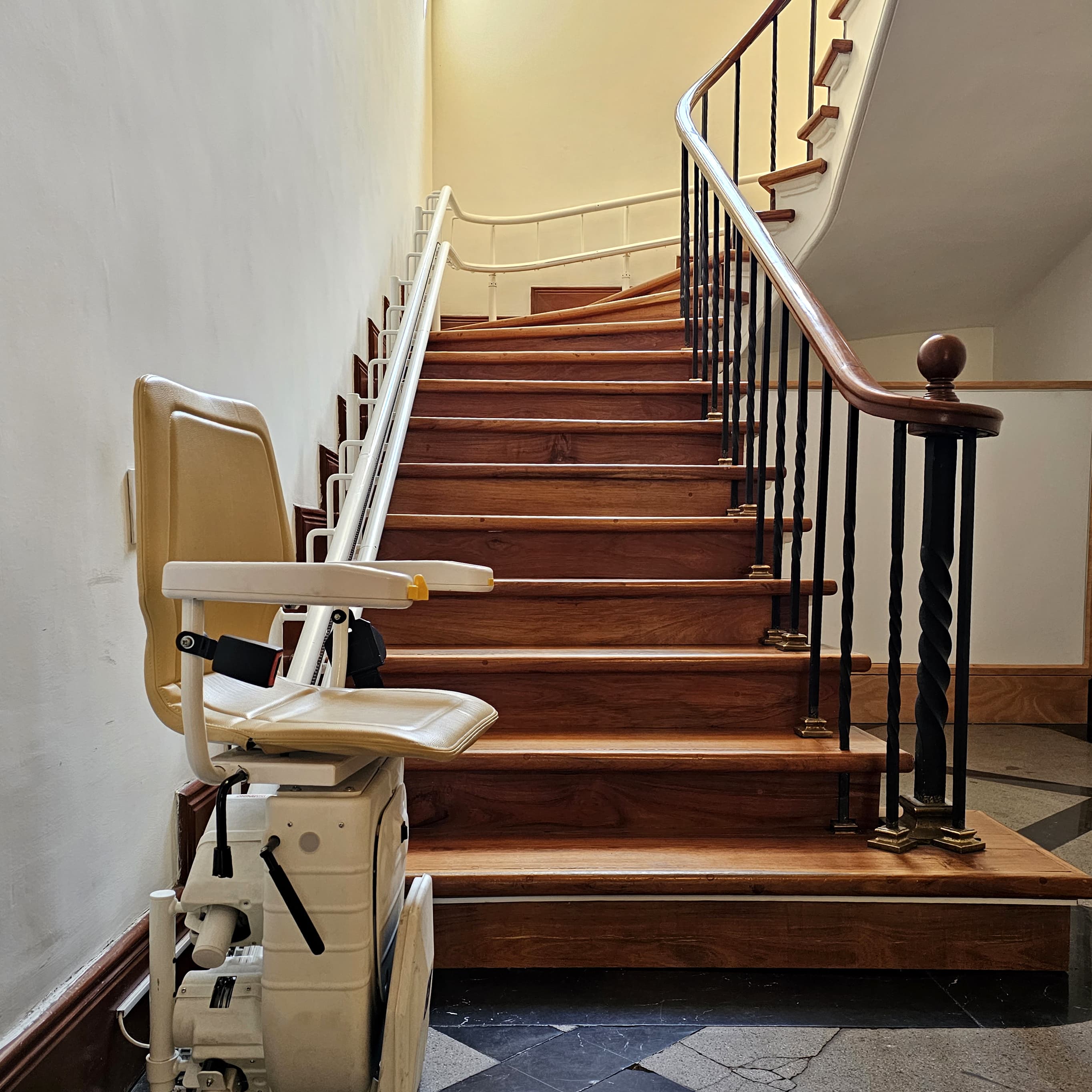 Sitzlift an einer Wendeltreppe eines Mehrfamilienhauses.