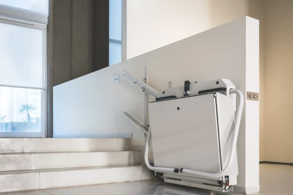 Hochgeklappter Plattformlift vor drei Stufen