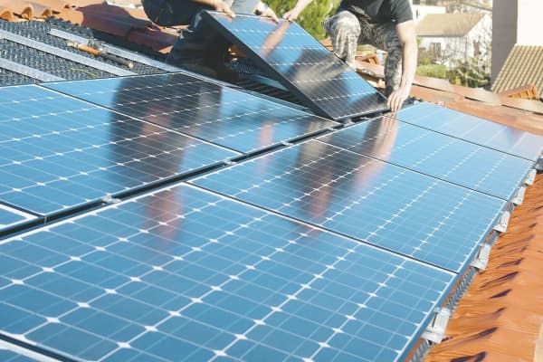 Monteure installieren Photovoltaikmodule auf einem Schrägdach