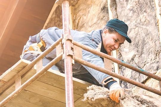 Fassadendämmung Mann auf Gerüst
