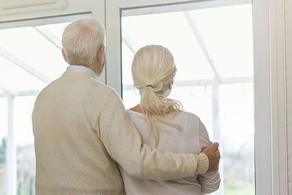 Älteres Ehepaar schaut aus dem Fenster