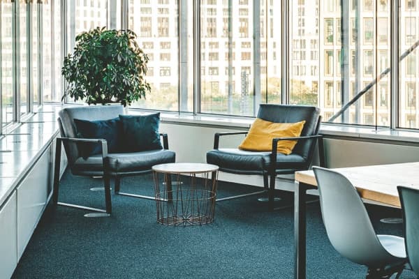 Das Bild zeigt eine Sitzecke mit zwei bequemen Sesseln im Aroundhome Büro mit Ausblick auf den Potsdamer Platz. Dieser Ort wird für unsere Experteninterviews genutzt.