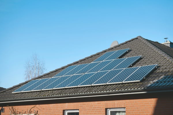 Einfamilienhaus mit großer Solaranlage auf dem Dach vor blauem Himmel