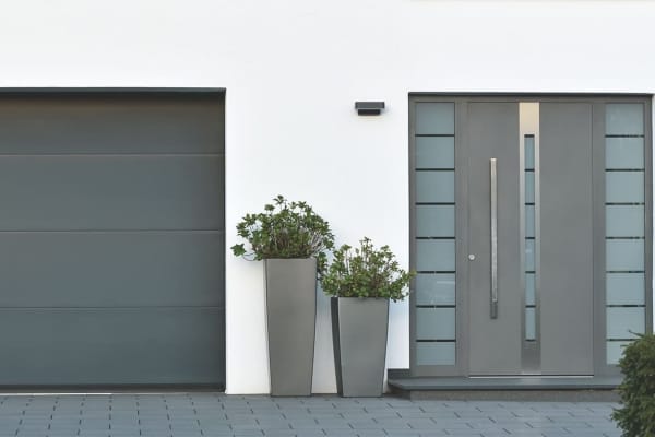 Ans Haus gebaute Garage mit Garagentor neben Hauseingang