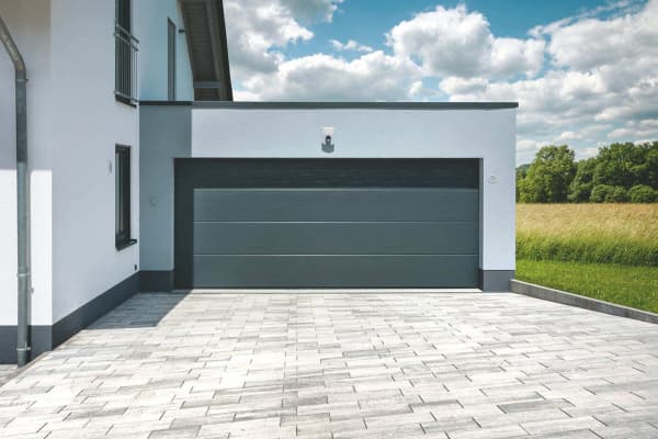 Garage mit breitem Tor an ein Wohnhaus gebaut