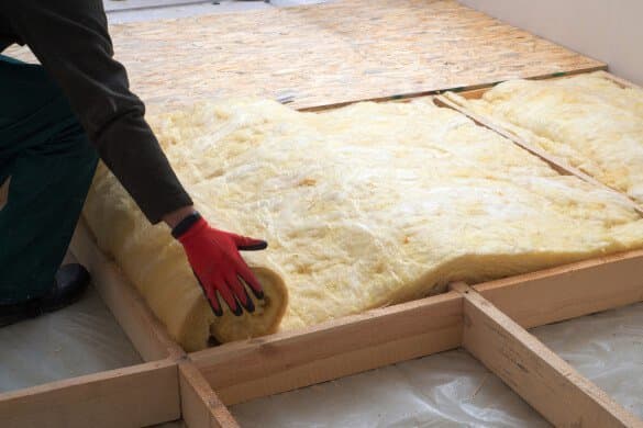 Handwerker legt Mineralwolle als Wärmedämmung aus