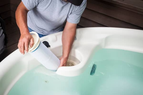 Mann wechselt Filter beim Whirlpool