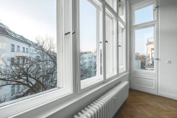 Helle Altbauwohnung mit großen Fenstern und Blick ins Grüne