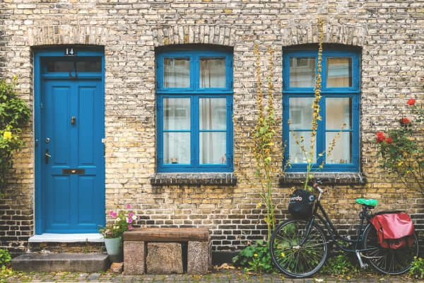 Das Bild zeigt dänische Fenster in leuchtendem Blau an einer Backsteinfassade
