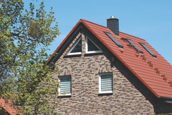 Einfamilienhaus mit rotem Satteldach und Dreiecksfenster