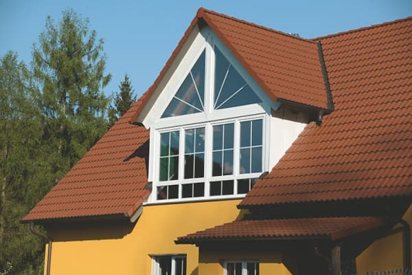 Haus mit rotem Satteldach und großer Giebelgaube