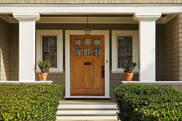 überdachter Hauseingang mit Holztür