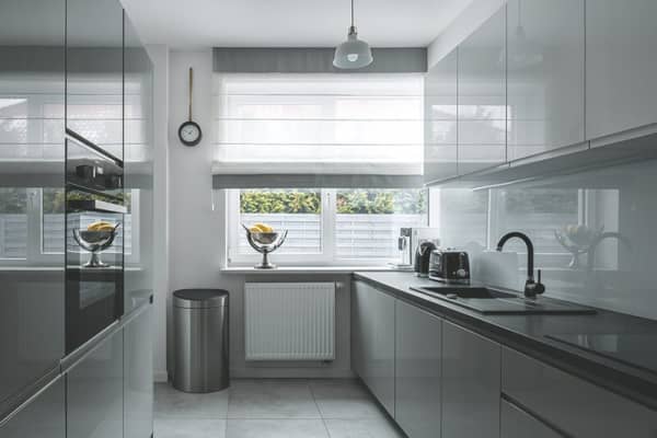 Moderne Küche in Grau mit Hochglanzfronten und großem Fenster