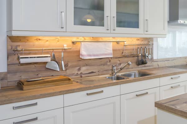 Weiße Landhausküche mit Holz-Arbeitsplatte