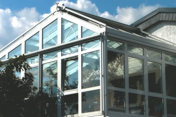 Wintergarten mit weißen Rahmen und großen Fensterfronten