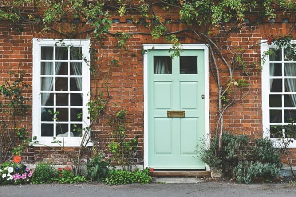 grüne Haustür aus Holz mit Glaseinsätzen