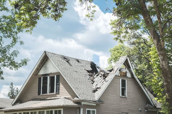 Haus mit schweren Sturmschäden braucht dringend eine Dachreparatur von Aroundhome
