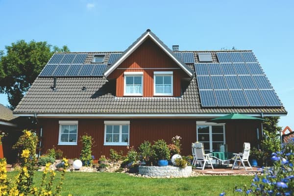 Einfamilienhaus mit sonniger Terrasse und einer Solaranlage auf dem Dach.