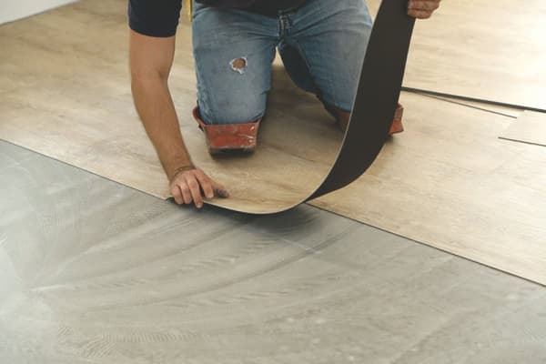 Bodenleger verlegt einen Vinylboden.