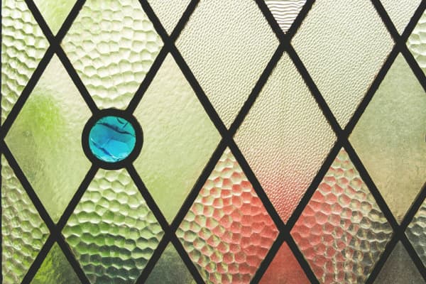 Detailansicht Bleiglasfenster mit Rautenmuster und blauem Glasstein