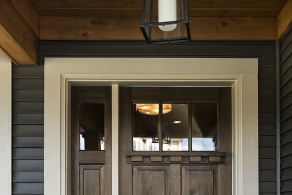 Hauseingangstür aus dunklem Holz mit Oberlicht aus Glas