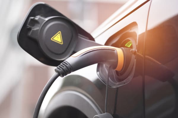 Nahaufnahme des Ladesteckers in einem dunklen E-Auto