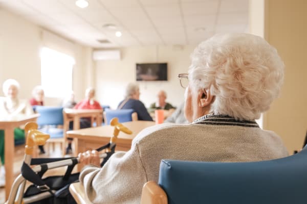 Senioren und Seniorinnen im Aufenthaltsraum eines Pflegeheims