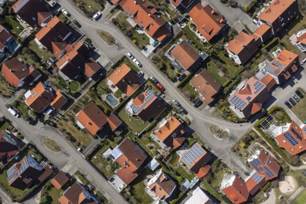 Luftaufnahme eines Wohngebiets mit Häusern, von denen einige mit Solaranlagen ausgestattet sind
