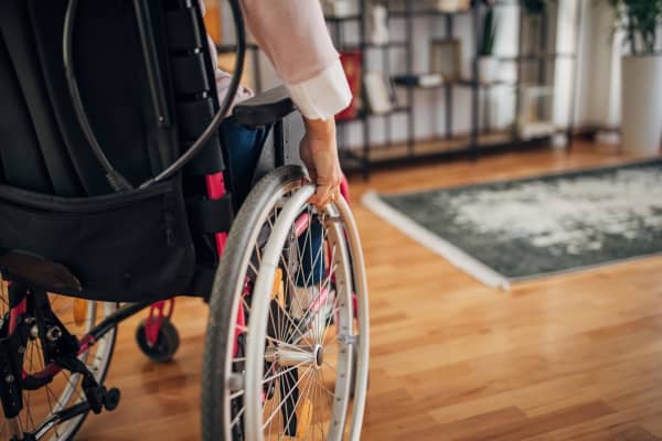 Nahaufnahme einer Rollstuhlfahrerin in ihrem Wohnzimmer zu Hause