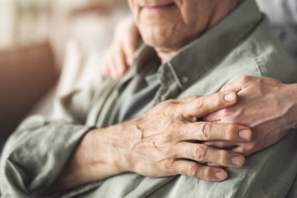 Hände einer Seniorin auf den Schultern eines Seniors