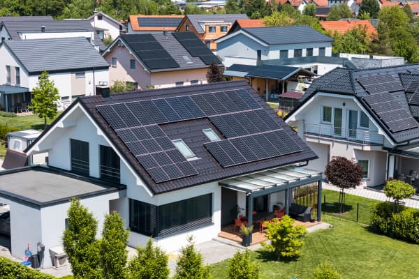 Wohngegend mit modernen Wohnhäusern, von denen einige Solarmodule auf den Dächern installiert haben