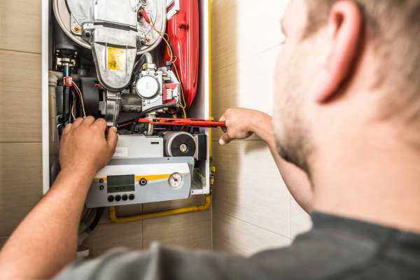 Monteur arbeitet an einer Gastherme