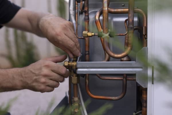 Installateur arbeitet an einer Wärmepumpe