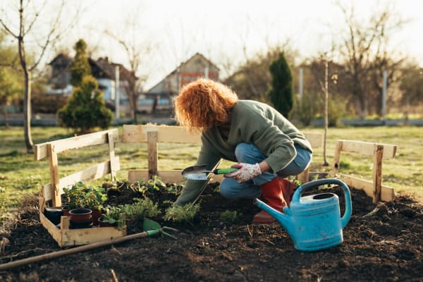 Frau im Garten im Beet